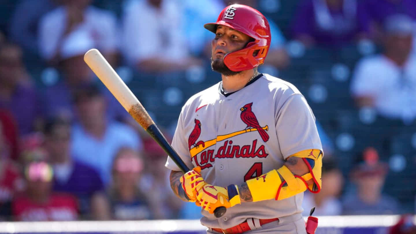 A Baseball Player Is Holding A Bat In Front Of A Crowd Wallpaper