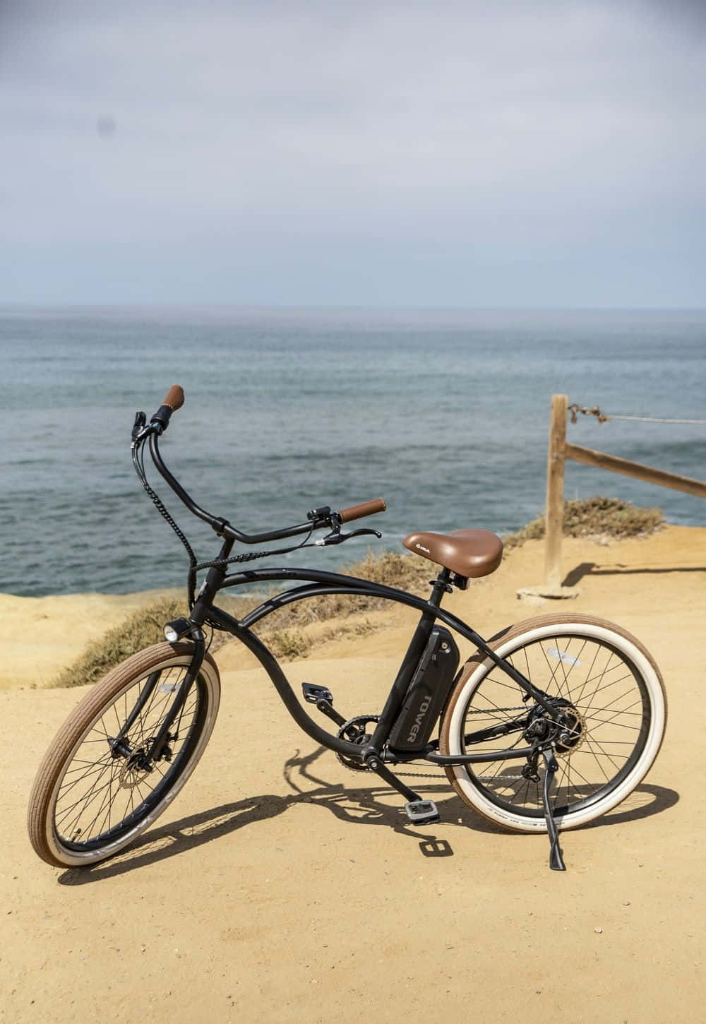 A Beach Cruiser Bicycle Parked On The Sandy Coast During A Vibrant Sunset Wallpaper