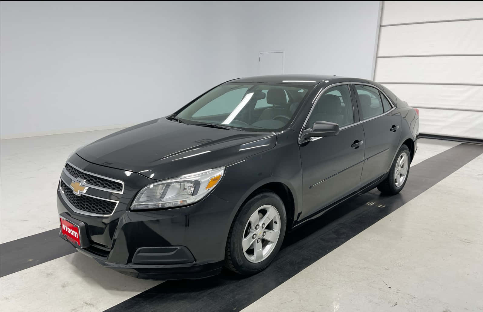 A Black Chevrolet Malibu Is Parked In A Garage Wallpaper