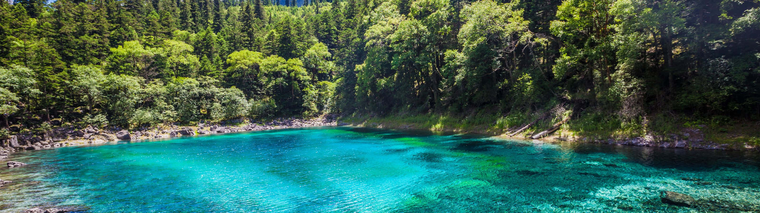 A Breathtaking View Of A Serene Blue Lake Surrounded By Green Mountains. Wallpaper