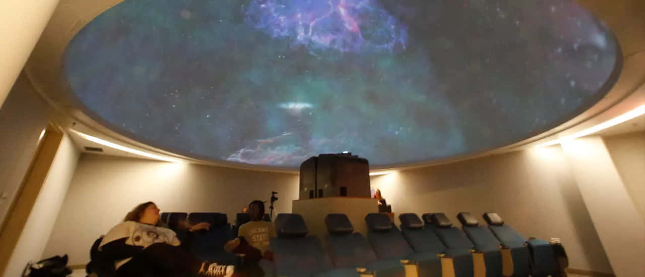 A Breathtaking View Of The Night Sky In A Planetarium Wallpaper