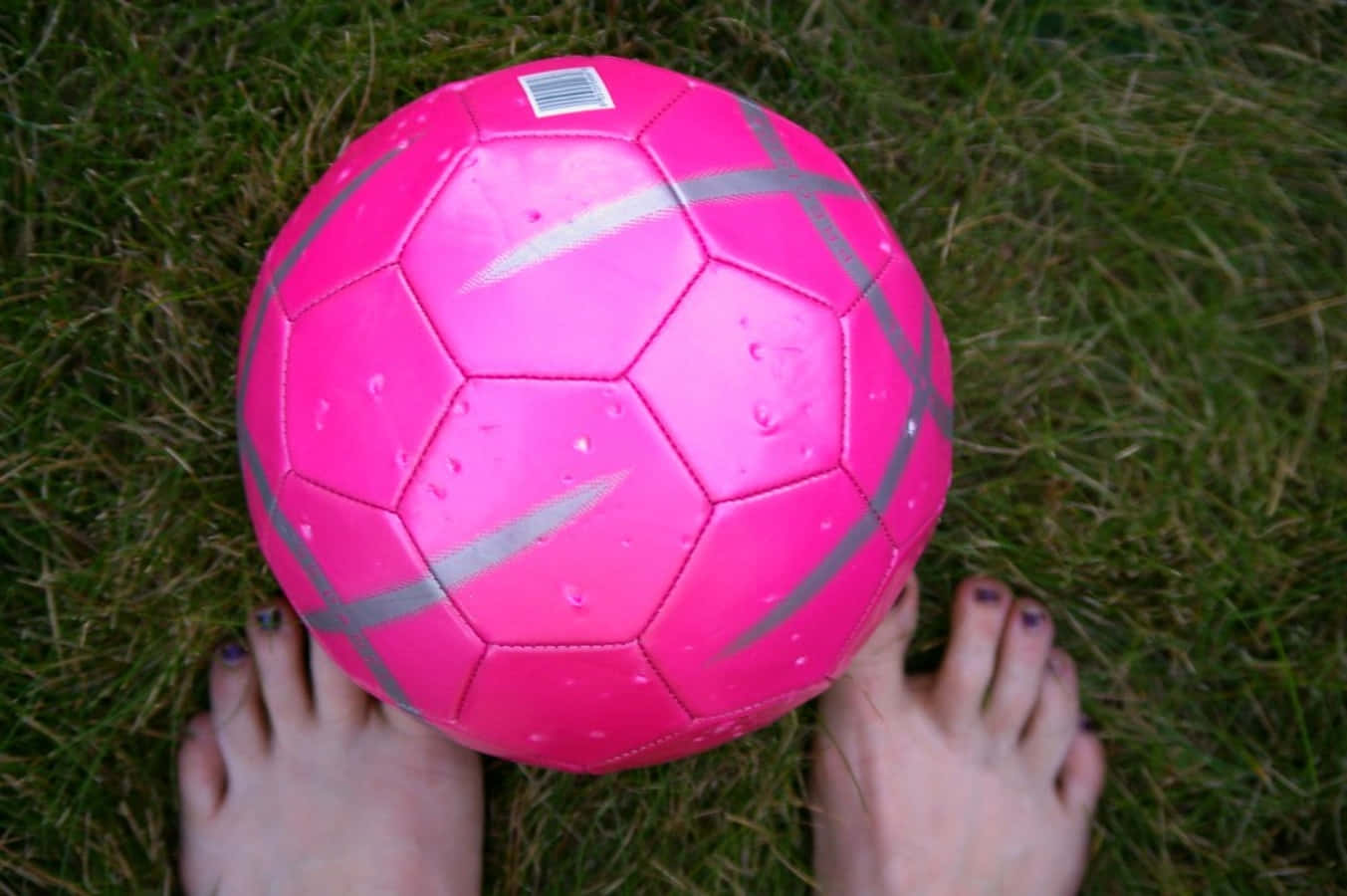 A Bright Pink Soccer Ball On A Grass Field Wallpaper