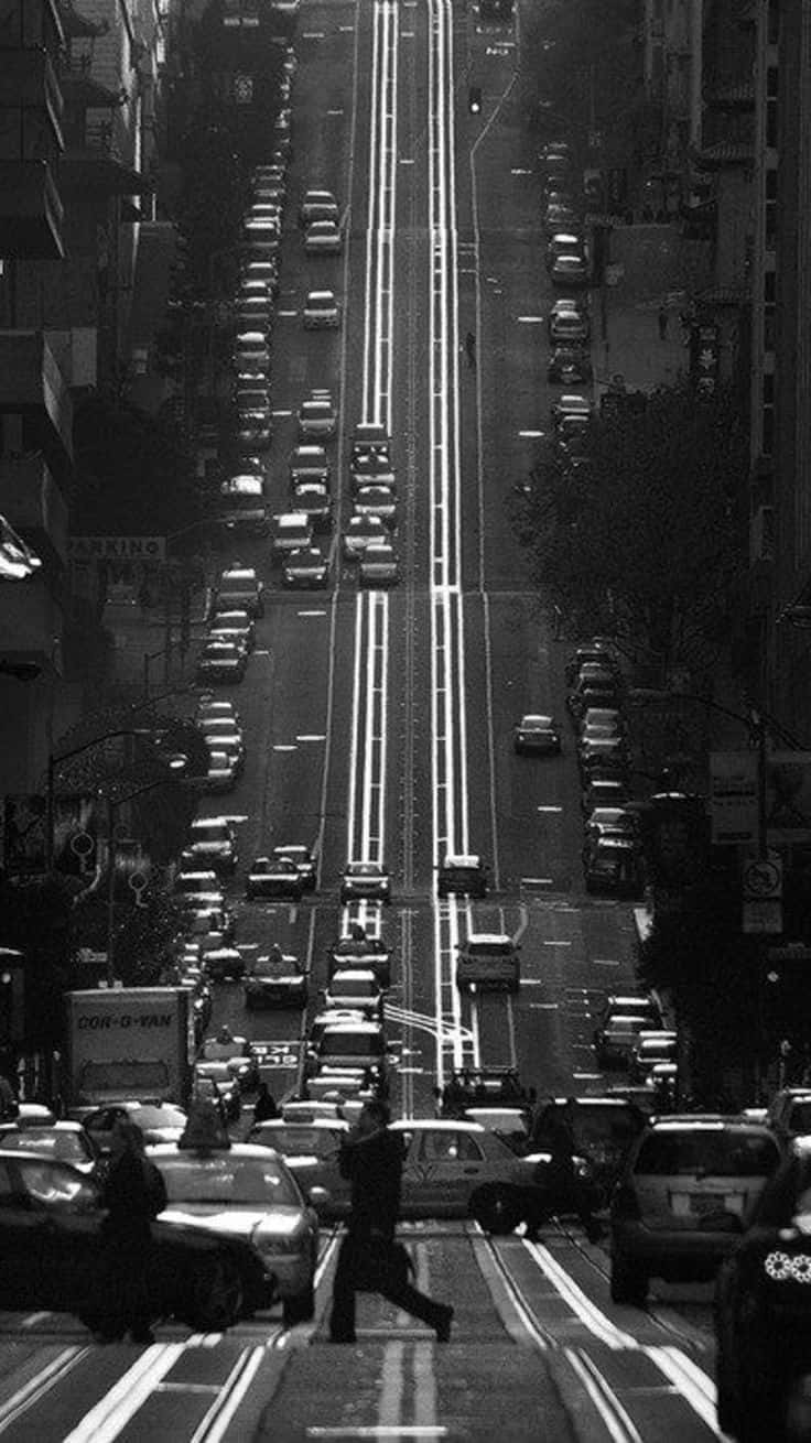 A Captivating Black And White Street Scene With A Lone Pedestrian Wallpaper