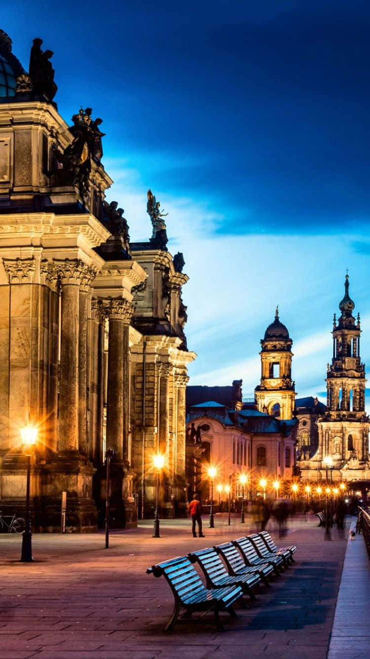 A City At Night With Benches And A Clock Wallpaper