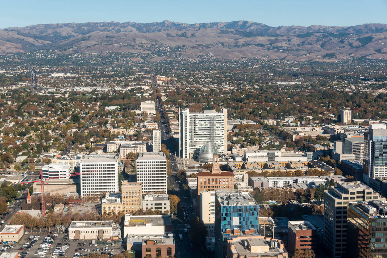 A City With Tall Buildings And Mountains In The Background Wallpaper