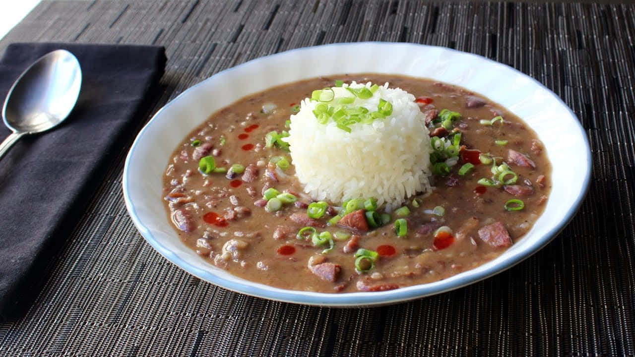 A Close-up View Of A Spoonful Of Cooked Red Beans Wallpaper