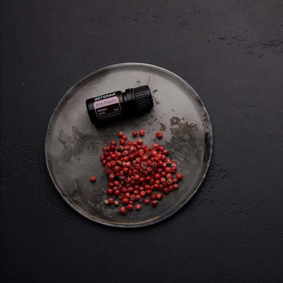 A Close-up View Of Beautiful Pink Peppercorns On A Wooden Surface. Wallpaper