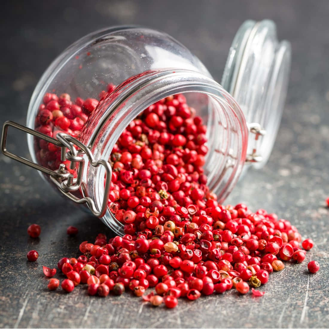 A Close-up View Of Vibrant Pink Peppercorns On A Wooden Surface. Wallpaper