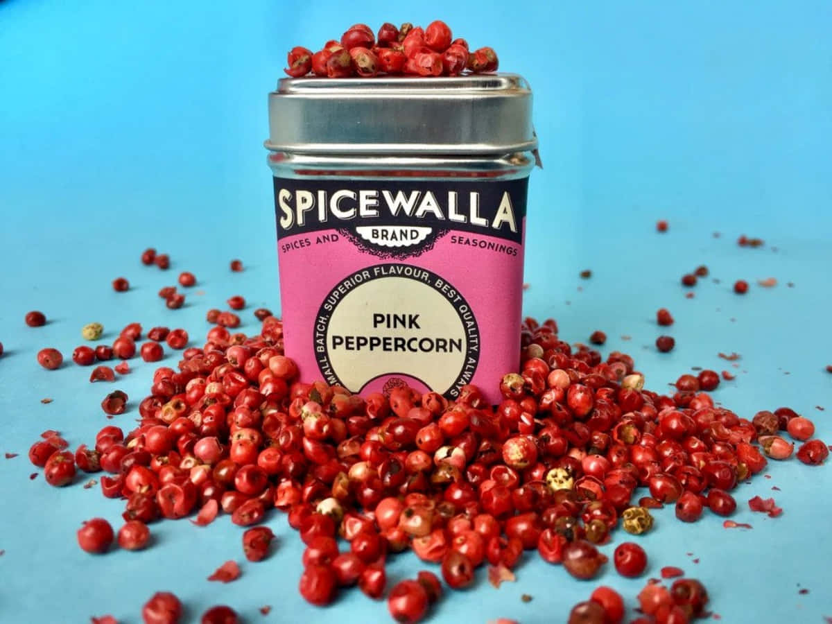 A Collection Of Pink Peppercorns On A Wooden Surface Wallpaper