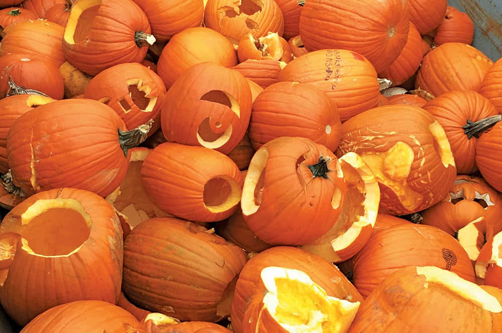 A Cozy Autumn Scene With Colorful Fall Pumpkins Displayed On Hay Bales Wallpaper