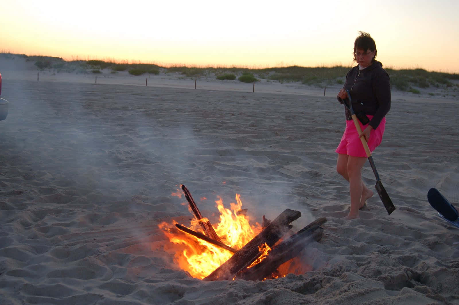 A Cozy Beach Campfire Under A Stunning Sunset Wallpaper