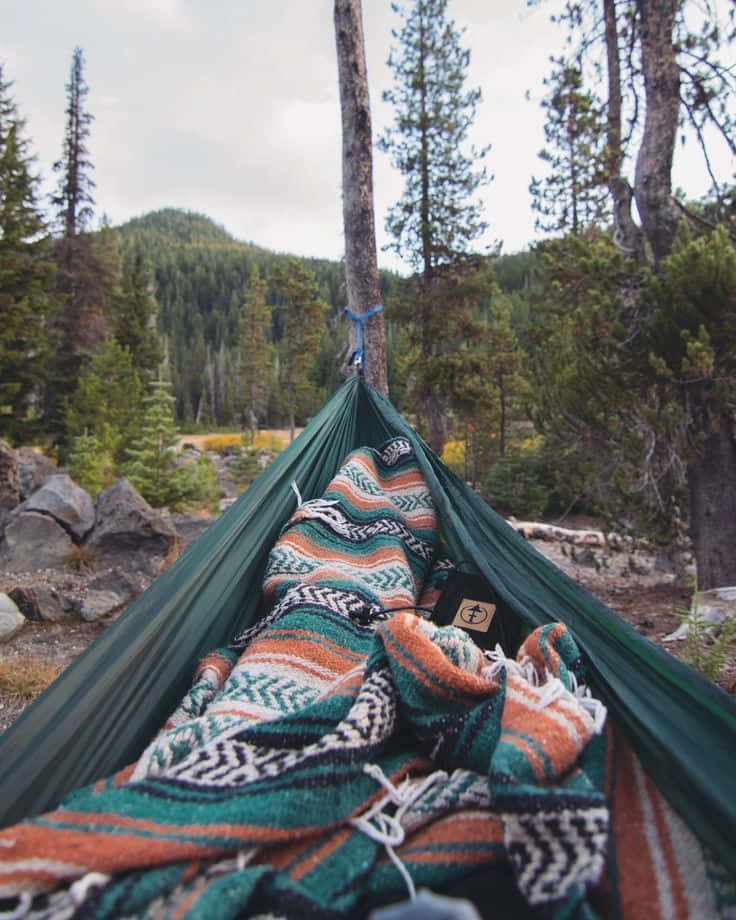 A Cozy Winter Camping Setup Amidst A Snowy Landscape Wallpaper