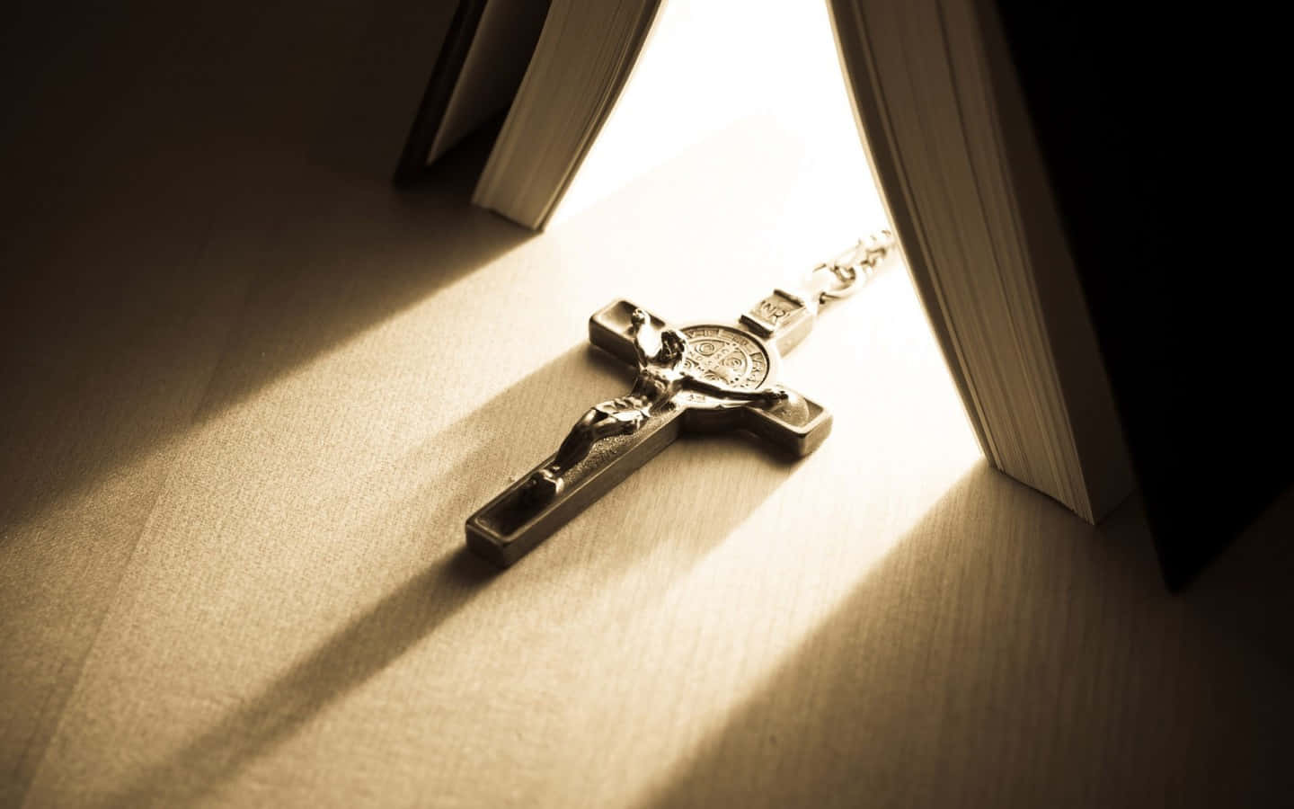 A Cross Hanging From A Book Wallpaper