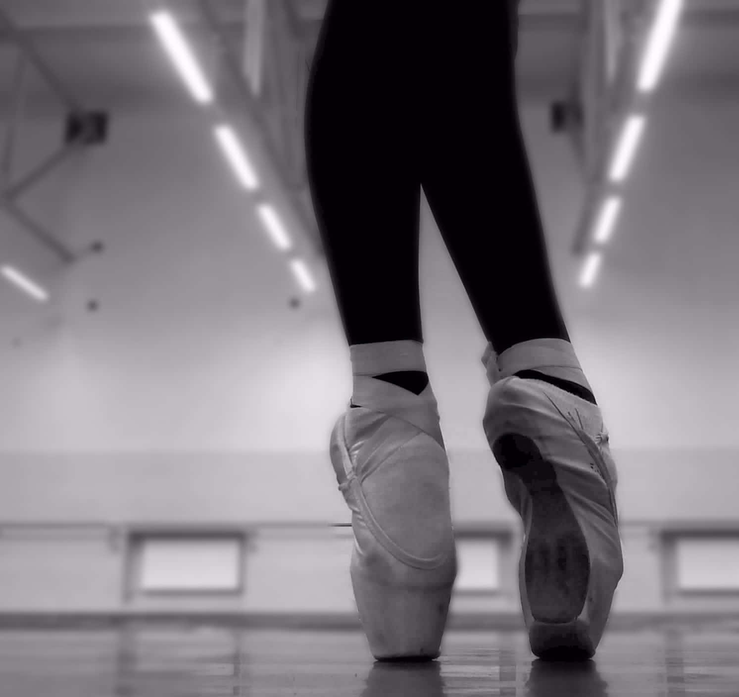 A Dancer Showing Off Her Beautiful Ballet Pointe Shoes. Wallpaper