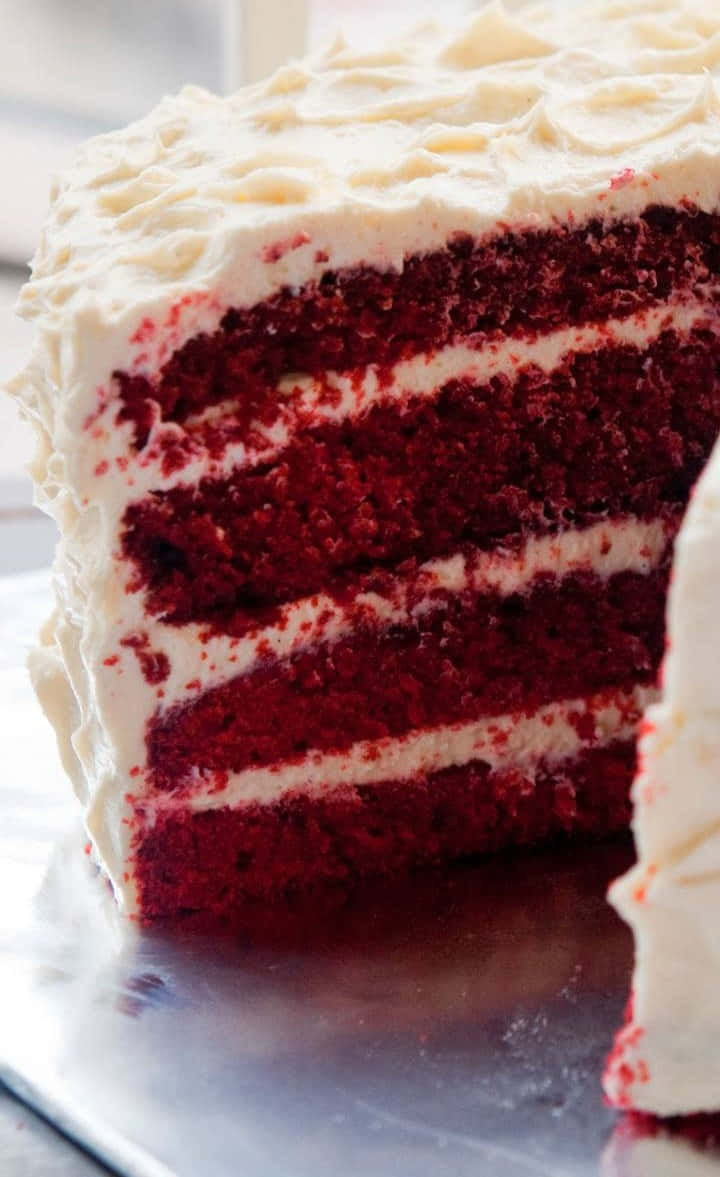 A Delicious Slice Of Red Velvet Cake Adorned With Cream Cheese Frosting Wallpaper