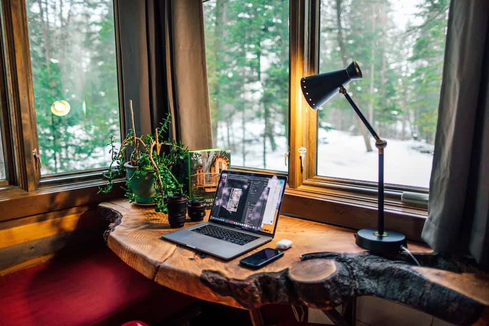 A Desk With A Laptop And A Lamp Wallpaper