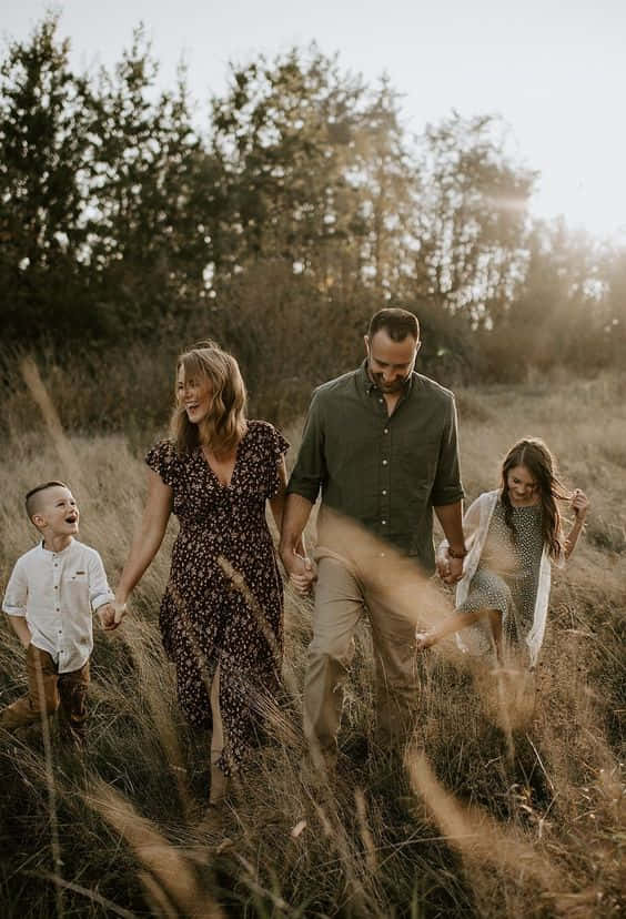 A Family Of Five Smiles Together On A Perfect Day. Wallpaper