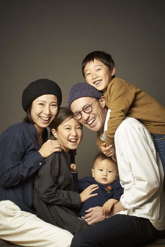 A Family Posing For A Photo Wallpaper