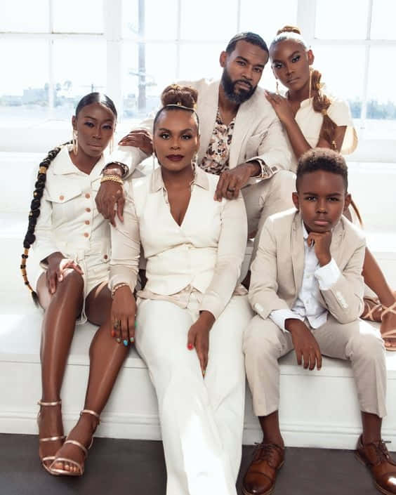 A Family Posing For A Photo In White Clothing Wallpaper