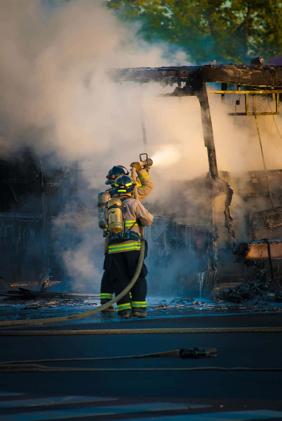 A Firefighter Is Battling A Fire Wallpaper