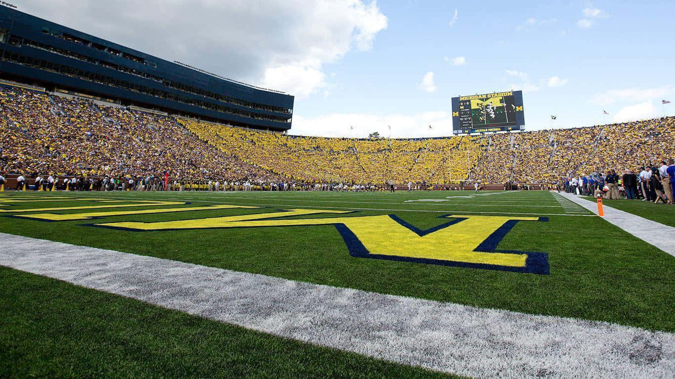 A Football Field With A Large Crowd Watching A Game Wallpaper