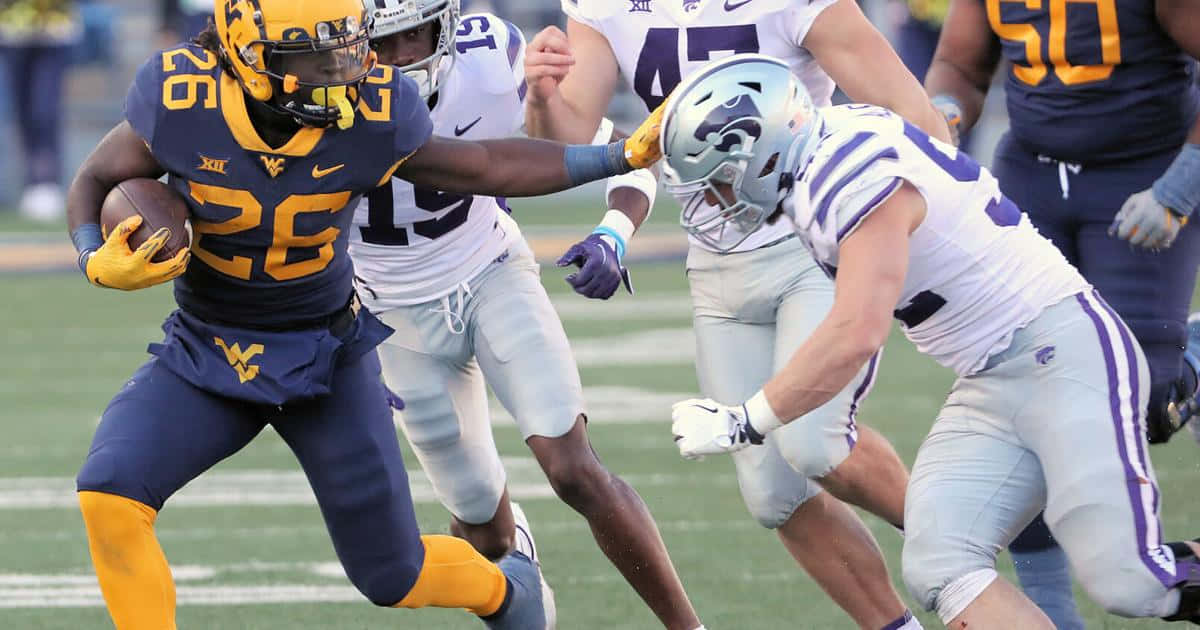 A Football Player Running With The Ball Wallpaper