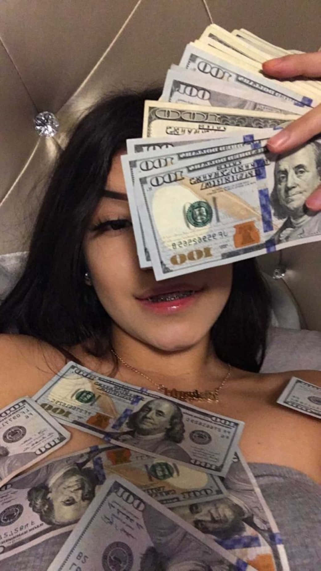 A Girl Laying On A Bed With A Bunch Of Money Wallpaper