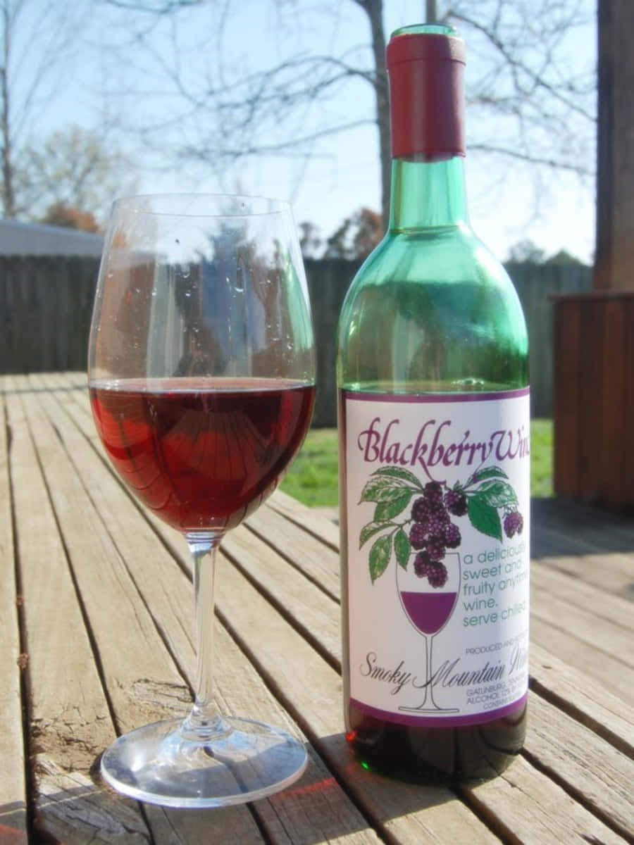 A Glass Of Blackberry Wine, Garnished With An Orange Slice Wallpaper