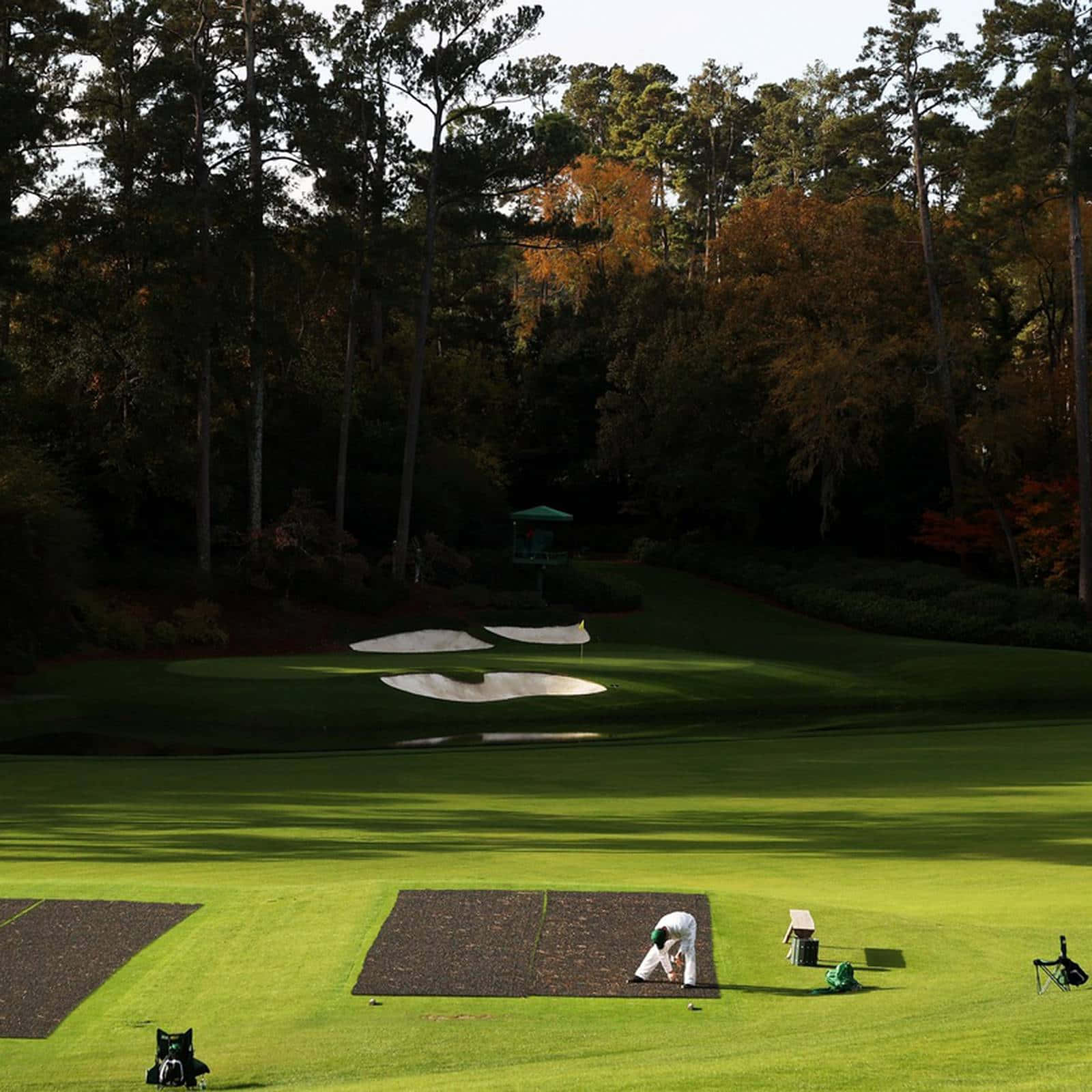 A Golfer Is Putting On A Green Wallpaper