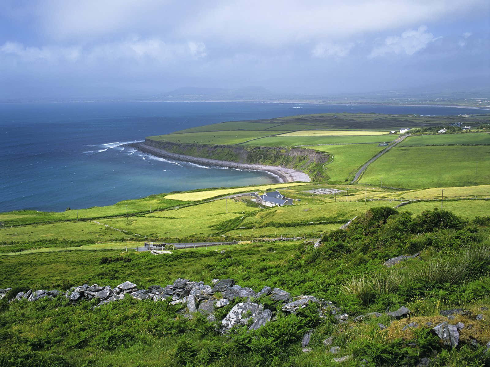 A Green Hillside With A View Of The Ocean Wallpaper