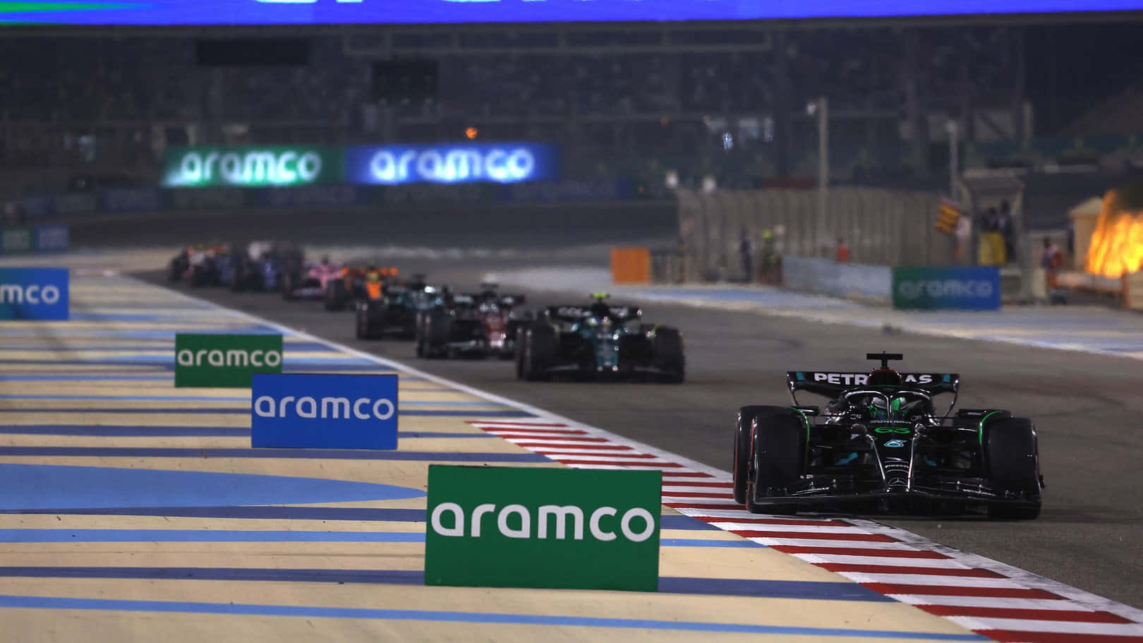 A Group Of Cars Are Racing Down A Track Wallpaper