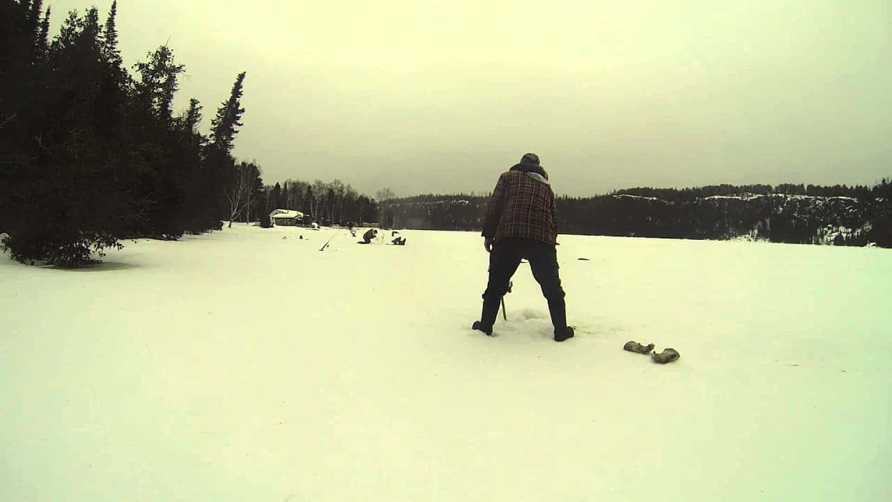 A Group Of Ice Fishers Enjoying Their Time By Drilling Holes In The Frozen Lake Wallpaper