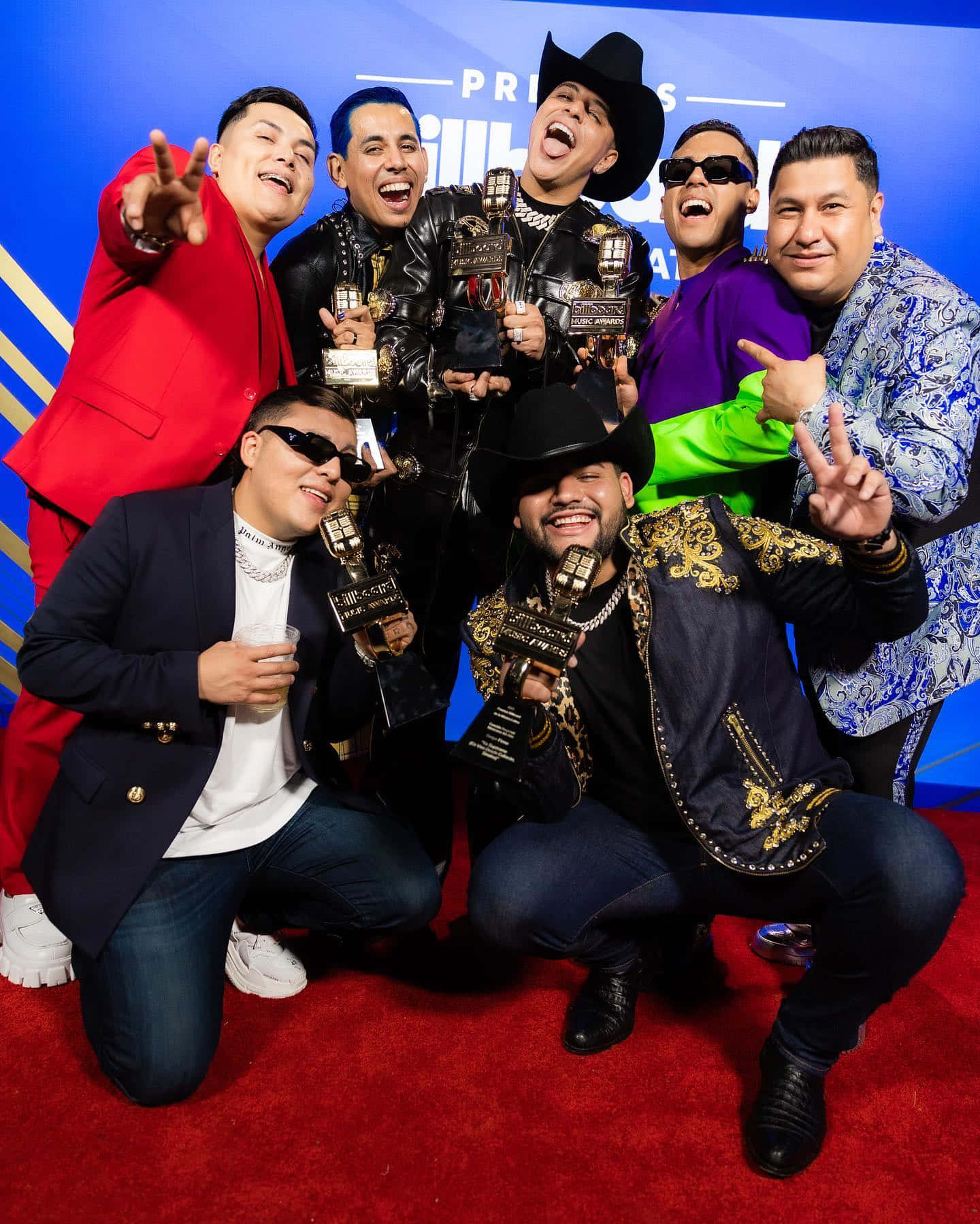 A Group Of Men Posing For A Photo On The Red Carpet Wallpaper