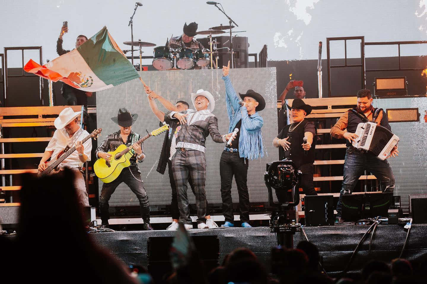 A Group Of People On Stage With A Mexican Flag Wallpaper