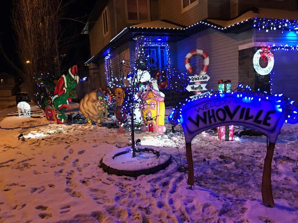 A House With Christmas Lights And Decorations In The Snow Wallpaper