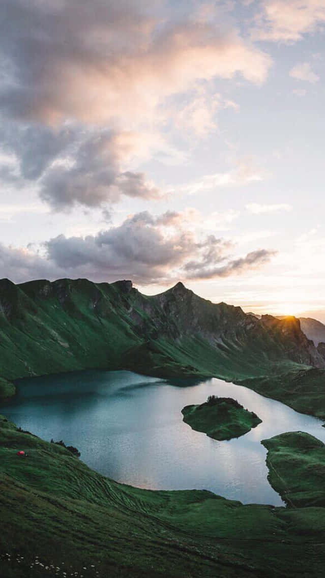 A Lake In The Mountains At Sunset Wallpaper