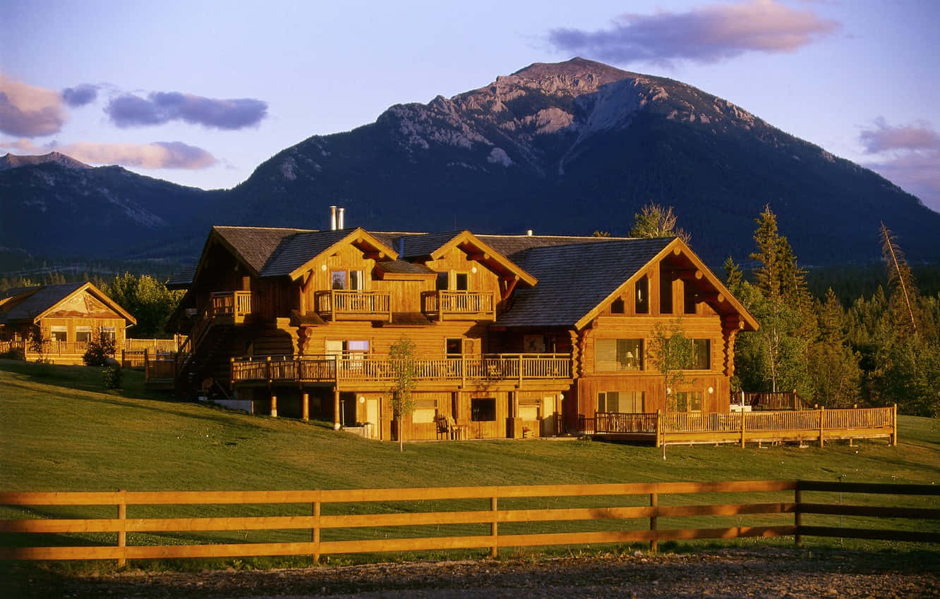 A Large Log Cabin In The Mountains Wallpaper