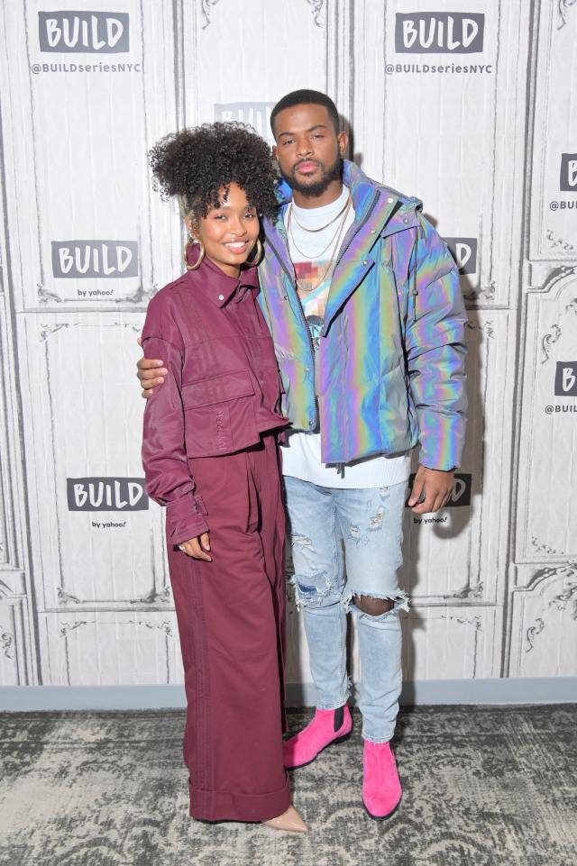 A Man And Woman Standing In Front Of A Wall Wallpaper