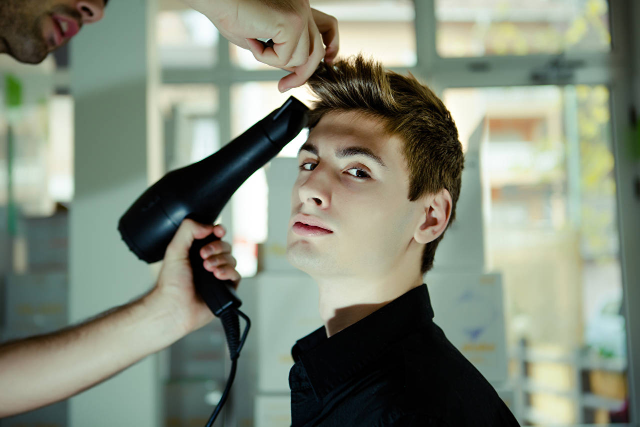 A Man Experiencing A Professional Hairstyling Session Aiming For A Fashionable Cowlick Style. Wallpaper