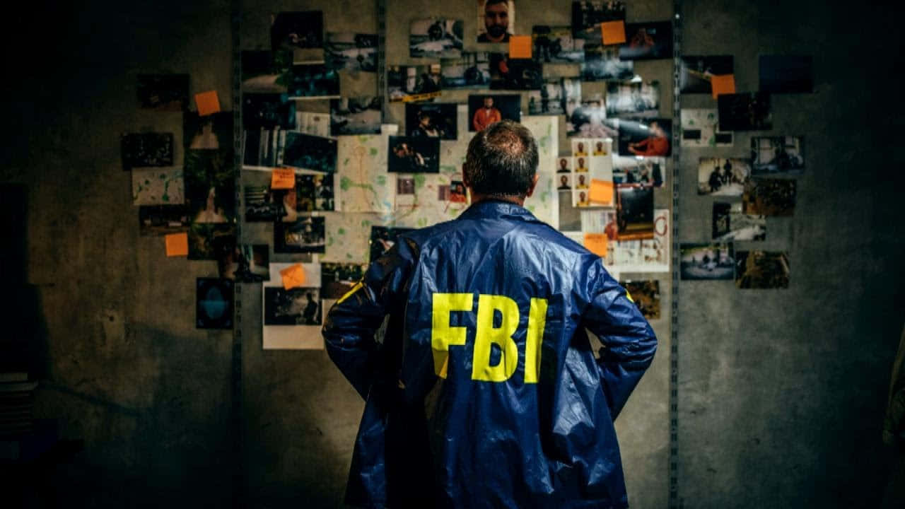 A Man In A Blue Coat Looking At Pictures On A Wall Wallpaper