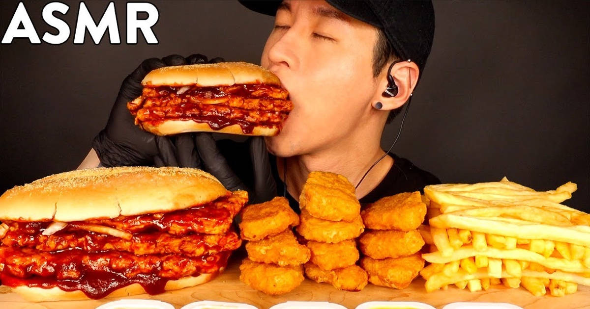 A Man Is Eating A Huge Burger With Fries Wallpaper