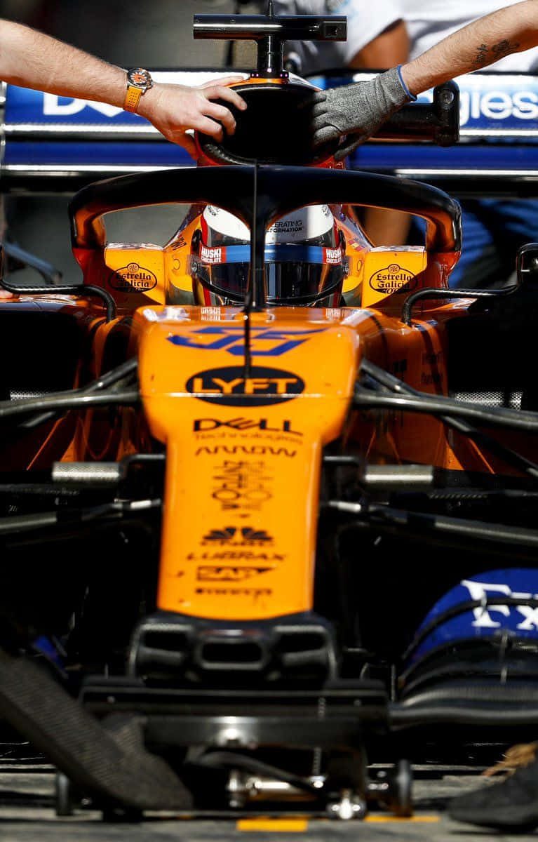 A Man Is Working On The Front Of A Racing Car Wallpaper