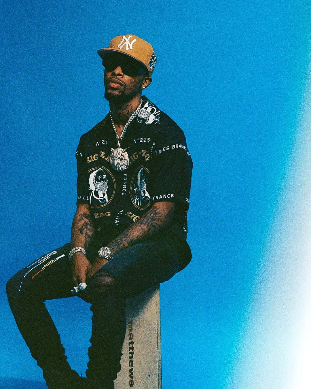 A Man Sitting On A Box With A Hat On Wallpaper