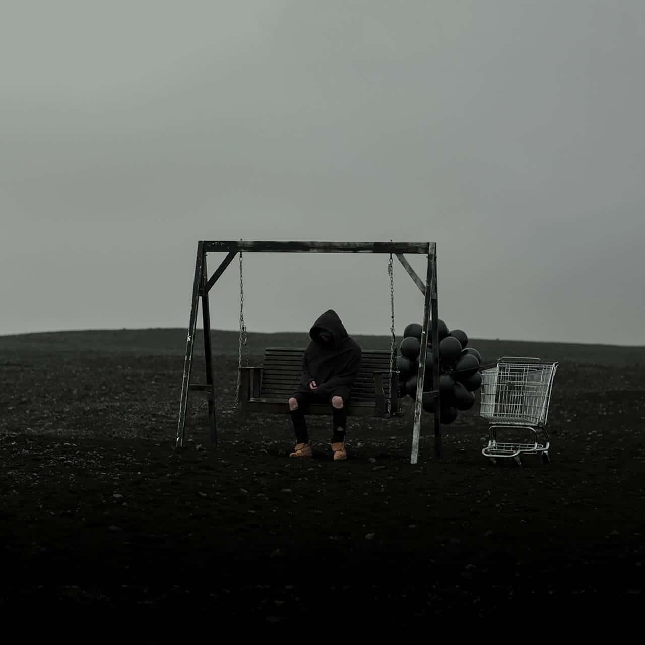 A Man Sitting On A Swing In A Field With Balloons Wallpaper