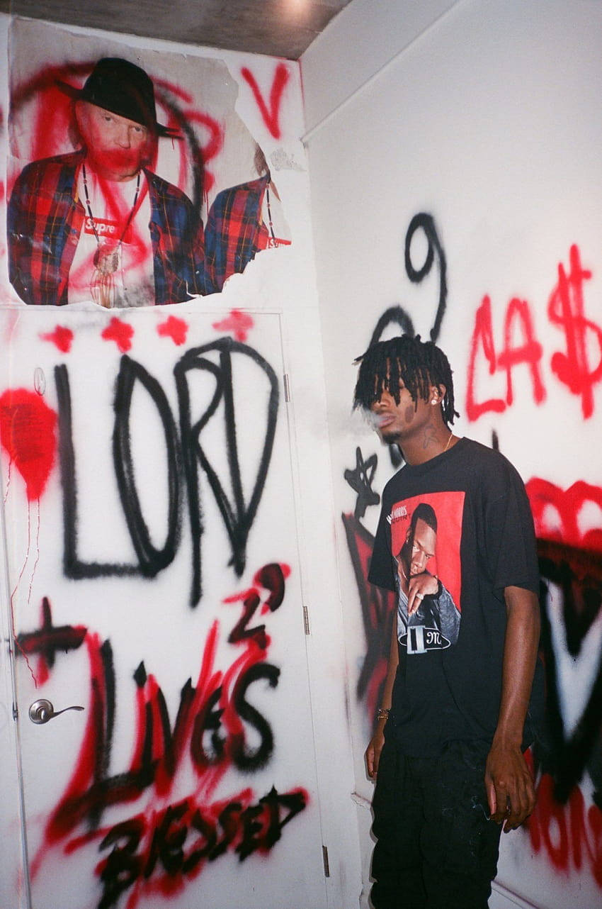 A Man Standing In Front Of A Wall With Graffiti Wallpaper