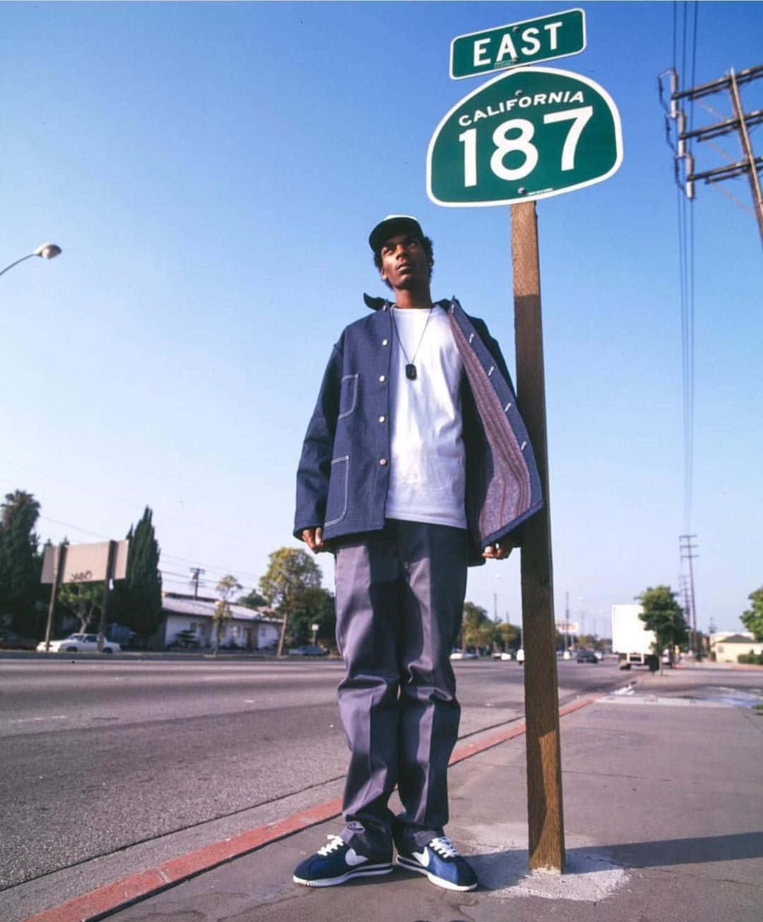 A Man Standing Next To A Street Sign Wallpaper