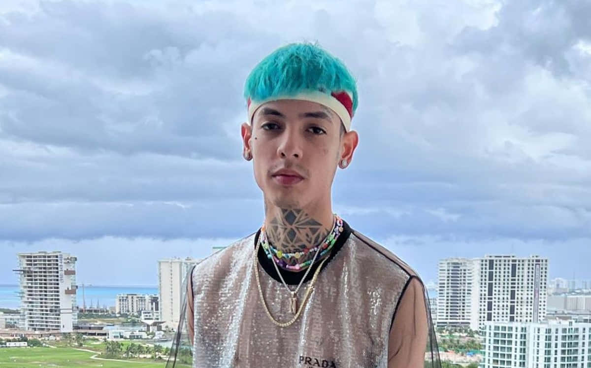 A Man With Blue Hair Standing In Front Of A Building Wallpaper