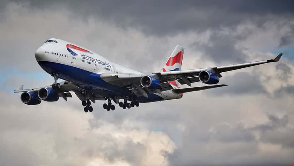 A Massive Jumbo Jet Hovering Above The Clouds Wallpaper