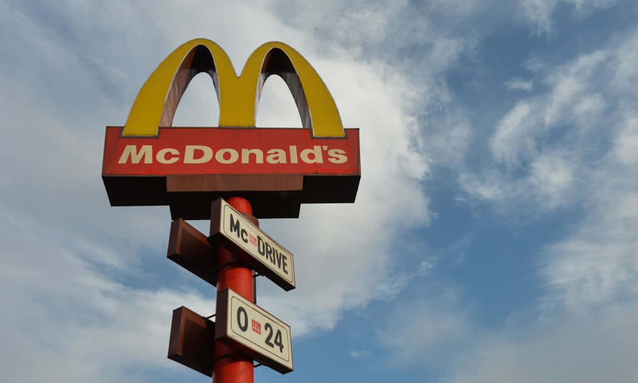 A Mcdonald's Sign Is Shown Against A Blue Sky Wallpaper