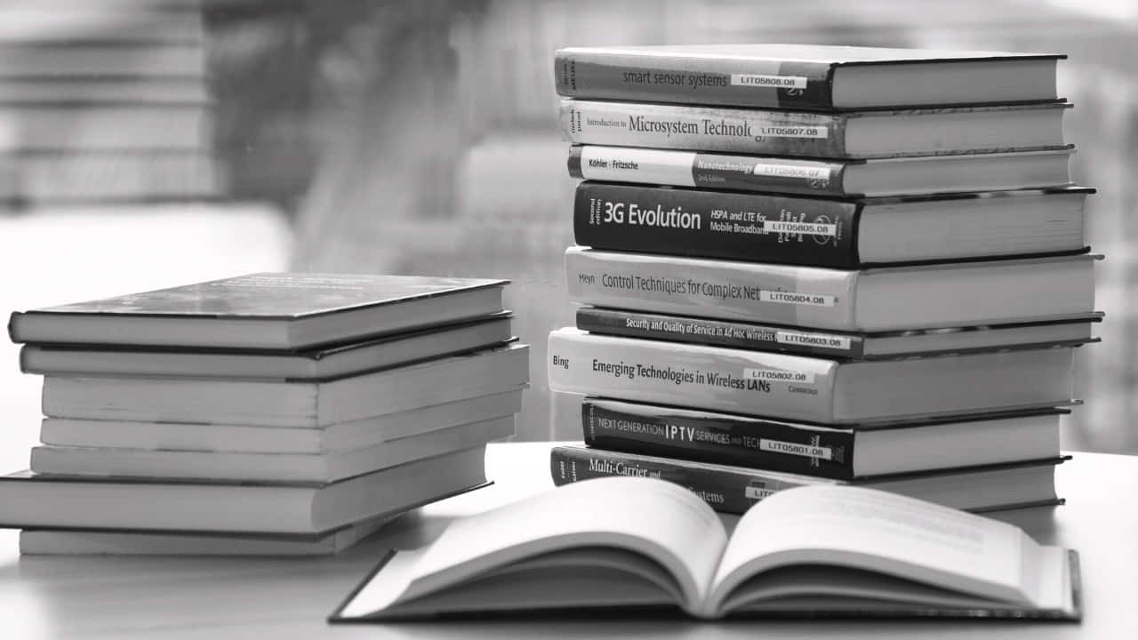 A Monochromatic Book Opened On A Table Amidst Nature Wallpaper